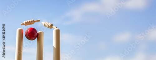 Cricket ball hitting wicket stumps and bails background