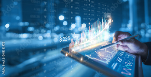 Displays a growing, virtual three-dimensional image of statistics, charts, and graphs with upward-pointing arrows against a dark background. 