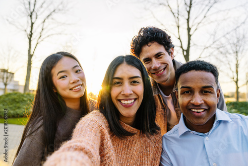 фотографія Diverse group of young friends smiling while taking a candid selfie on an urban