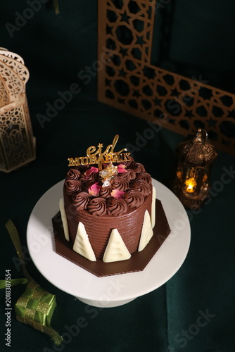 Chocolate cake (sponge, mousse, crunch, sauce) arranged artistically and separated on the plate, with Eid Mubarak topper.