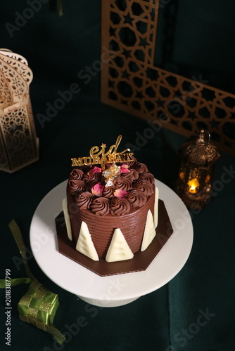 Chocolate cake (sponge, mousse, crunch, sauce) arranged artistically and separated on the plate, with Eid Mubarak topper.