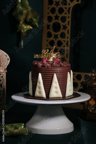 Chocolate cake (sponge, mousse, crunch, sauce) arranged artistically and separated on the plate, with Eid Mubarak topper.