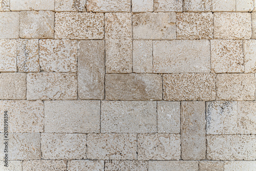 Foto Close-up of a natural limestone brick wall with rough porous stone blocks in neutral beige tones