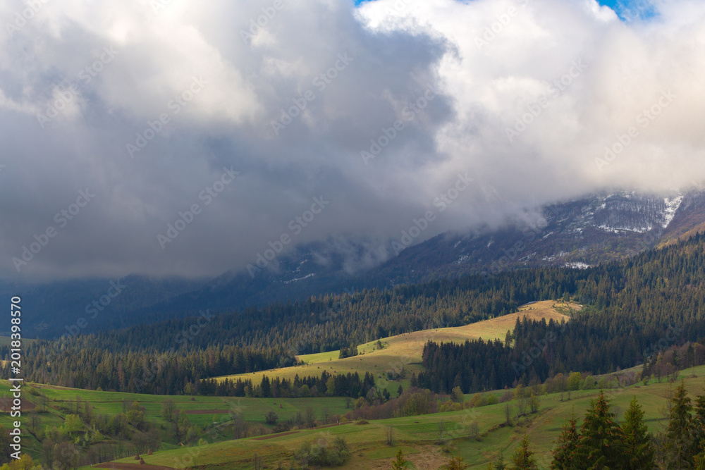 Fototapeta premium Dramatic clouds of the autumn Carpathian mountains at early morning in the sunrise.