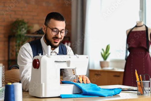 Male tailor using sewing ma...
