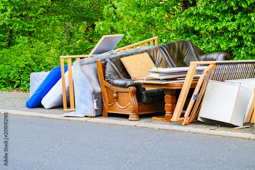 Canvas Print Discarded furniture and mattresses piled up on the curb for collection