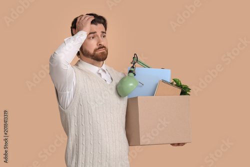 Fired young man holding box...