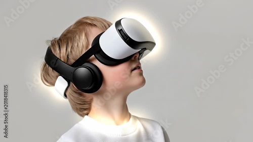 Slow motion tracking static shot of boy turning head while wearing virtual reality headset in neutral studio