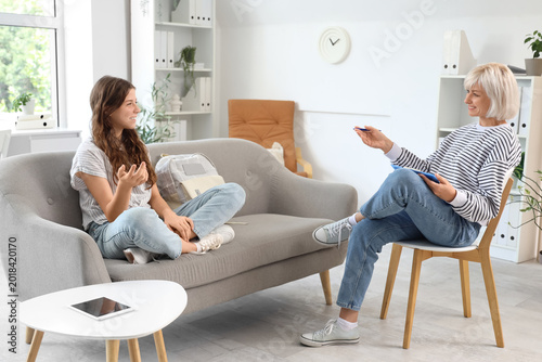 Female psychologist talking to teenage girl in office
