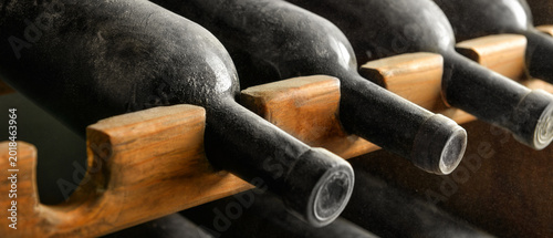 Canvastavla Wooden holder with bottles of wine in cellar, closeup