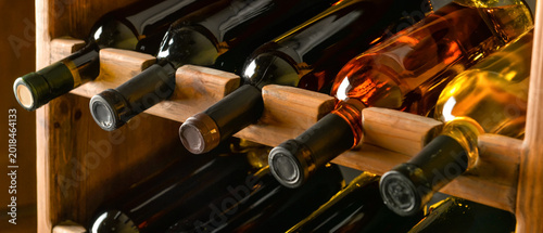 Foto Wooden holder with bottles of wine in cellar