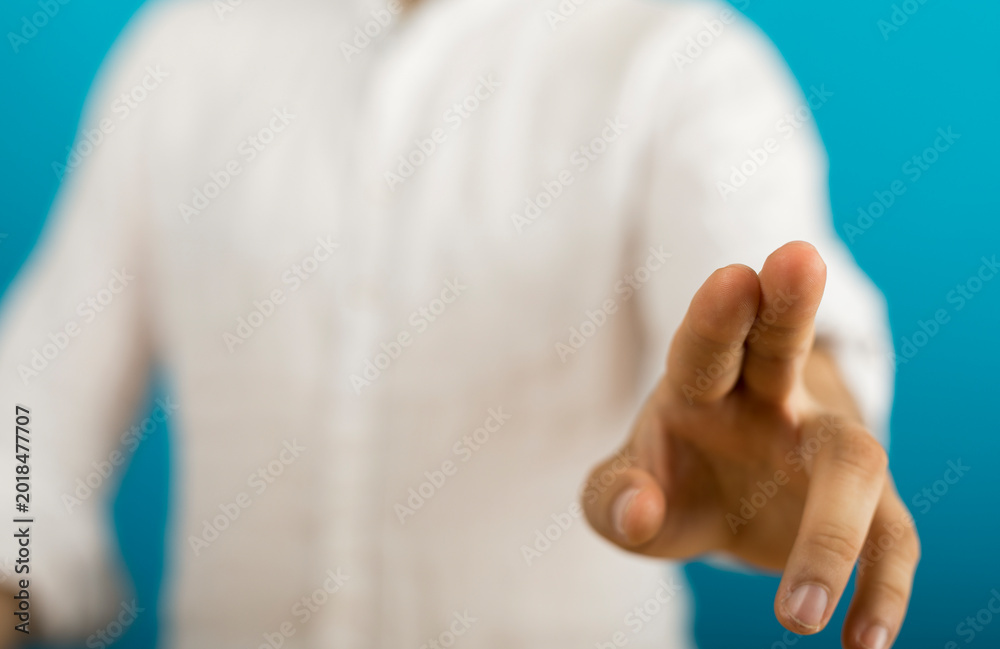 Naklejka premium Hand reaching forward in gesture, isolated on blue. Focus, choice, decision concept.