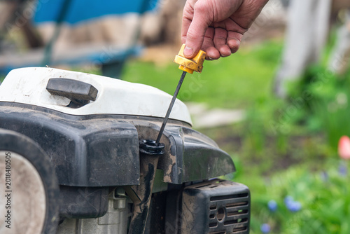 Checking the oil level in the cultivator with a dipstick