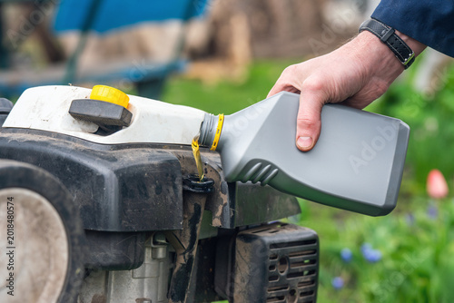 Filling a cultivator with motor oil and servicing garden equipment