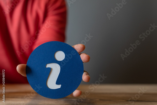 Hand holding a blue circula...