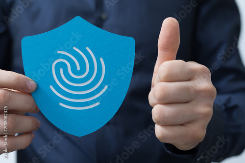Man holds a blue shield wit...