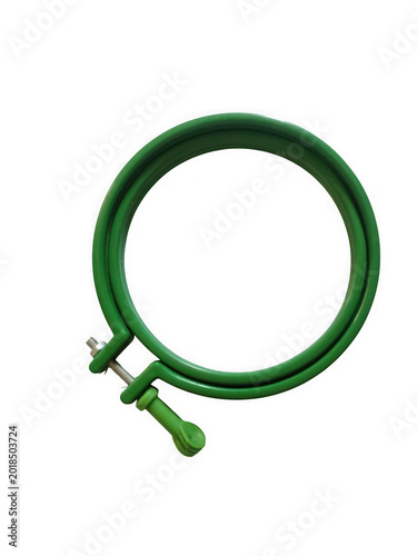 Green embroidery hoop with a metal clamp on a white surface