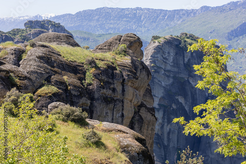 Bilde på lerret stunning aerial view of the majestic meteora sandstone rock formations in greece under a clear blue sky, featuring lush greenery and distant snow-capped mountains