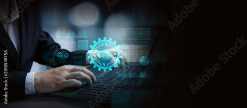 Canvastavla Navigating Technological Frontiers: A close-up view of a person engrossed in work, their hands dancing over a laptop keyboard, as a holographic interface of gears and a world map hovers