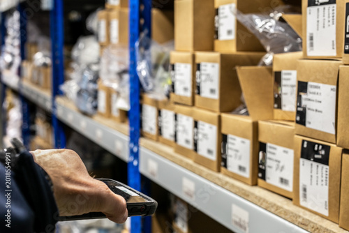 Photography Warehouse worker using a handheld RF scanner (Radio Frequency scanner) to instan