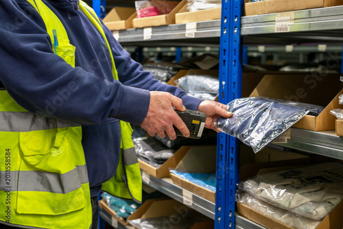 Photos Logistics warehouse operative wearing a high-visibility yellow vest and using ha