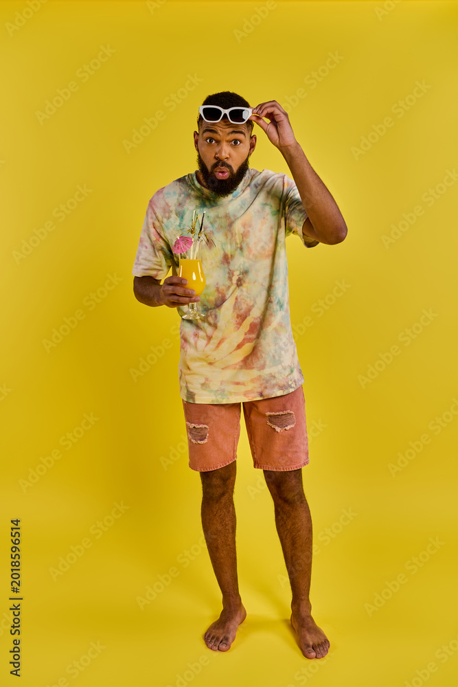 Naklejka premium Vibrant young man enjoying a refreshing drink in a colorful summer setting