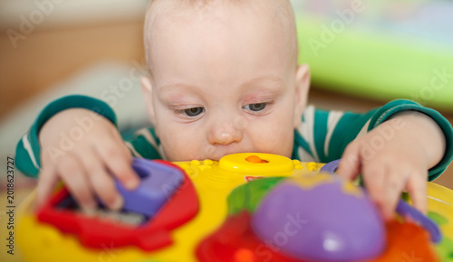 Bild auf Leinwand Curious infant marvels at a vibrant yellow activity toy, tiny fingers and explor