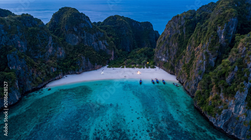 Aerial view of Maya Bay, a stunning tropical beach with turquoise waters and limestone cliffs in Thailand.