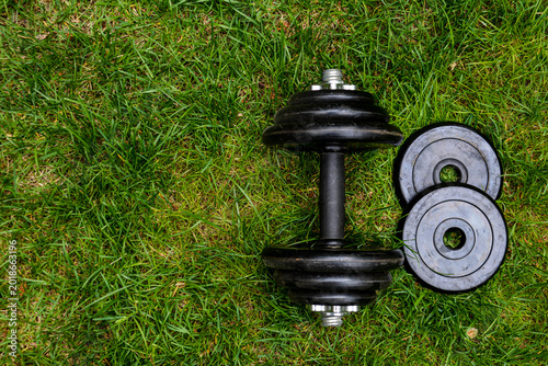 Dumbbells on green grass background. Fitness and healthy lifestyle concept. Fitness equipment on the grass. Bodybuilding
