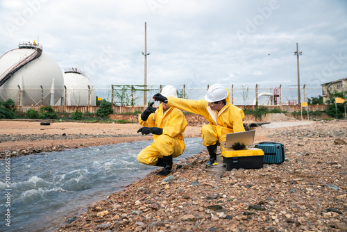 Environmental Inspection Team Performing Water Quality Testing Near Industrial Pollution Site During Wastewater Monitoring And ESG Compliance Assessment