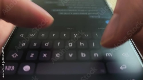 Hands type on a smartphone keyboard in close up. Text entry continues as fingers tap the mobile screen during chat input. Digital messaging and app communication concept..