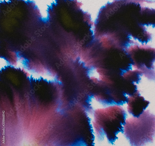 Ink blending and diffusing on paper creating a vibrant, abstract background with shades of purple, blue, pink, and dark green, showing a watercolor effect