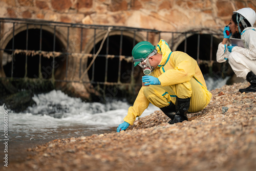 Environmental Worker Inspecting Polluted Drainage Tunnel During Industrial Wastewater Monitoring And Hazardous Contamination Assessment Operation In Protective Suit Onsite