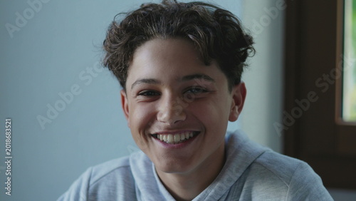 Foto Teen boy smiling warmly indoors with relaxed joyful expression, creating lighthe