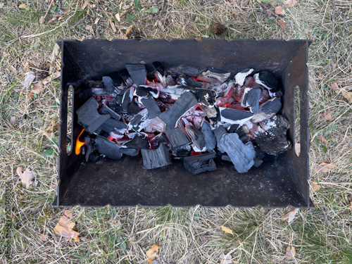 Photography Smoldering coals in a portable metal grill, close-up of an outdoor barbecue with