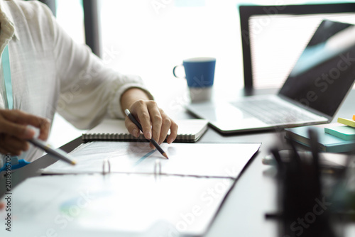 Canvastavla person writing on documents with pencil at desk with laptop and coffee mug in br