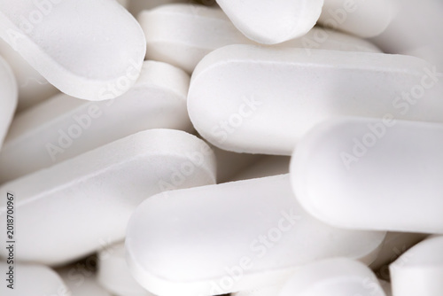 Macro close up of white oval medical pills background