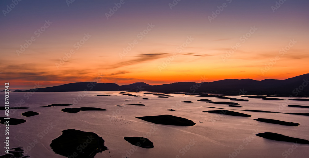 Naklejka premium Aerial sunset view over Clew Bay near Westport, County Mayo, Ireland. Scenic Atlantic bay with drumlin islands and mountain silhouettes on the Wild Atlantic Way.