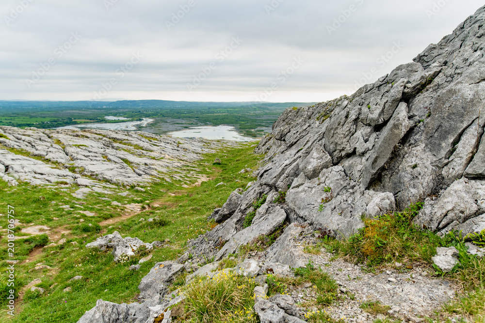 Fototapeta premium Limestone pavement landscape in Burren National Park, County Clare, Ireland. Wild karst scenery on the Wild Atlantic Way with views across the Irish countryside.