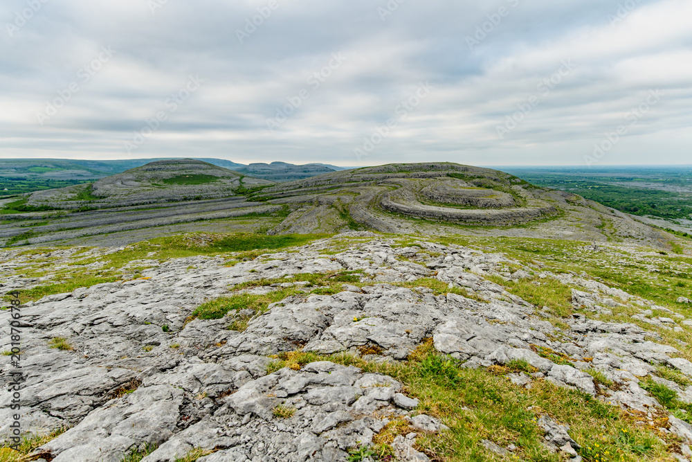Fototapeta premium Limestone pavement landscape in Burren National Park, County Clare, Ireland. Wild karst scenery on the Wild Atlantic Way with views across the Irish countryside.