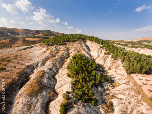Fotografie Pistachio orchards on heavily eroded semi-arid terrain with calcareous badlands formations