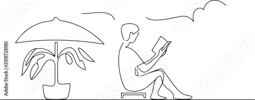 Tableau sur toile A person sits under an umbrella reading a book next to a plant on a sunny day wi