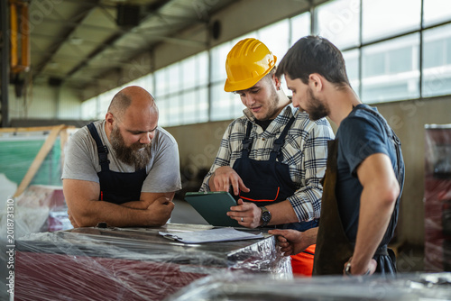Canvastavla Factory workers collaborating and discussing manufacturing plans