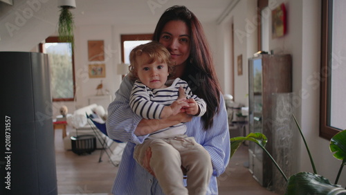 Fotografía Mother holding toddler in bright living room creating warm affectionate moment f