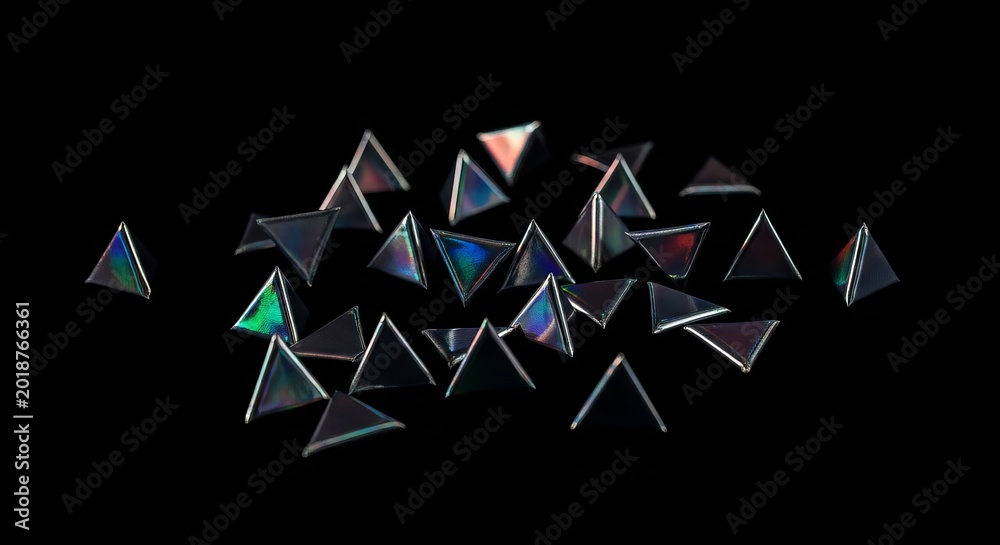Obraz premium Scattered Iridescent Triangular Geometric Shapes with Reflected Light Against a Dark Background
