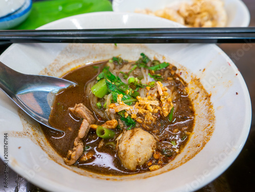 Foto Traditional Thai boat noodles with thick spicy pork broth, meatballs, and liver