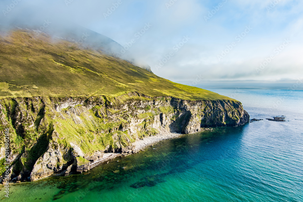 Fototapeta premium Aerial view of the southern end of Keel Beach on Achill Island, County Mayo, Ireland. White pebbles, turquoise water and steep cliffs define this rugged Atlantic cove.