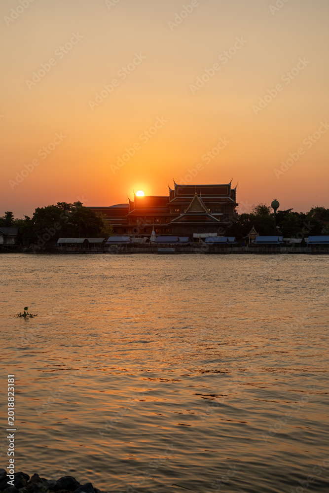 Fototapeta premium Sunset sky with the silhouette of riverside building