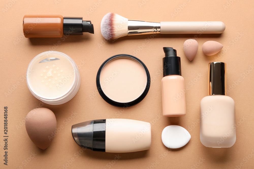 Fototapeta premium Face powders, foundation, brush and sponges on beige background, flat lay