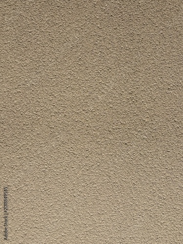 Foto Beige textured stucco wall surface with rough plaster finish background